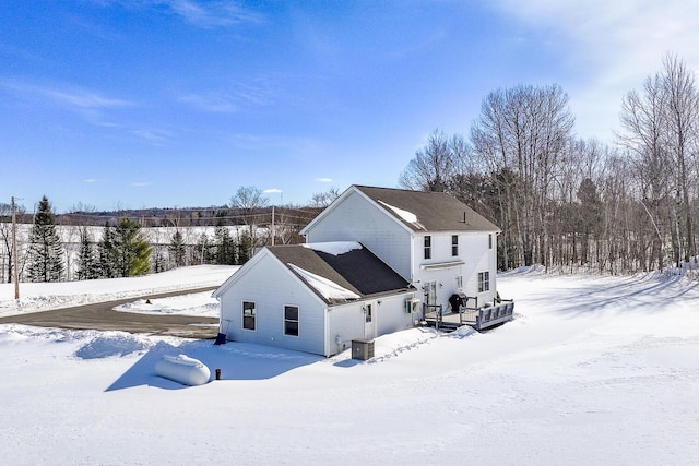 snow covered back of property with central AC