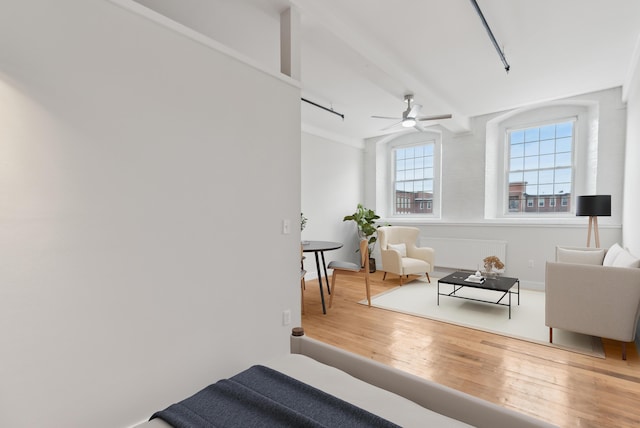 sitting room featuring a ceiling fan, rail lighting, and wood finished floors