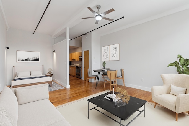 living room featuring light wood-type flooring, baseboards, and a ceiling fan