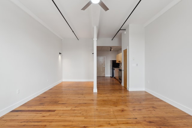 spare room with a ceiling fan, light wood-style flooring, and baseboards