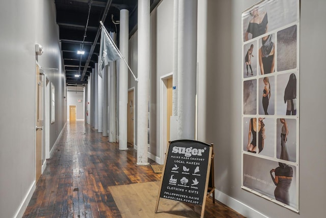 corridor with wood-type flooring and baseboards