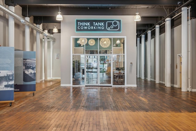 spare room with wood-type flooring, baseboards, and a high ceiling