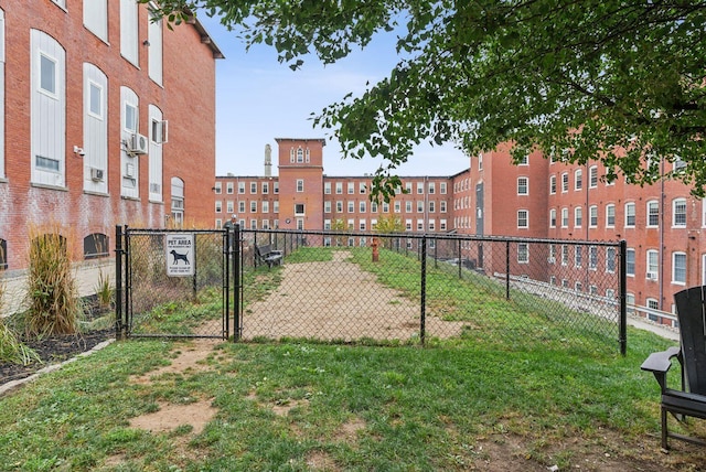 surrounding community featuring a gate, fence, and a lawn