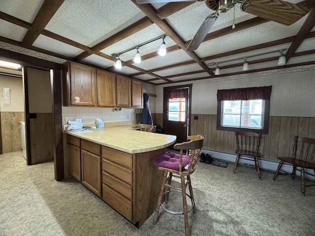 143 Main St, Sangerville, ME 04479 - kitchen featuring a wainscoted wall, light colored carpet, brown cabinets, light countertops, and a kitchen breakfast bar
