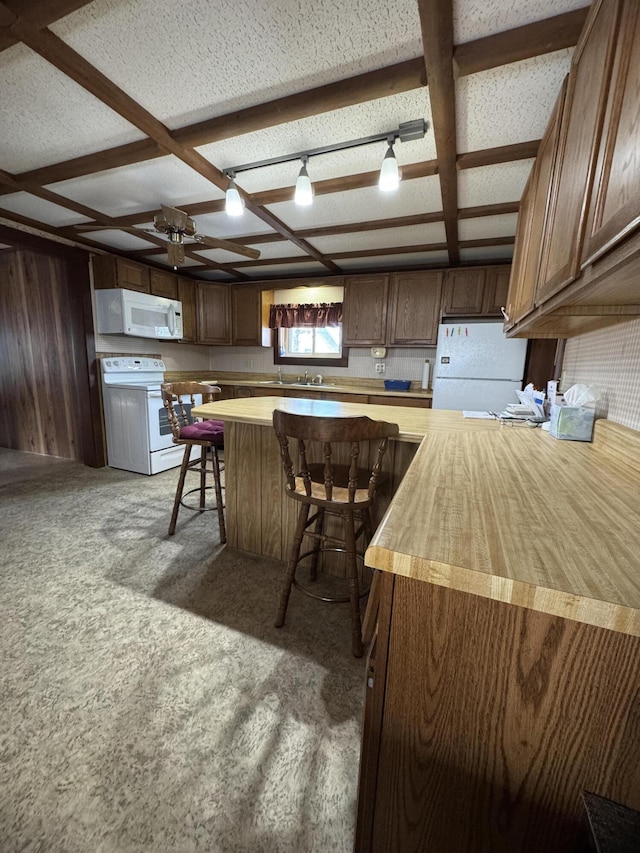 143 Main St, Sangerville, ME 04479 - kitchen with white appliances, ceiling fan, a breakfast bar, a sink, and wood walls
