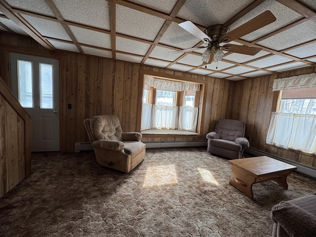 143 Main St, Sangerville, ME 04479 - carpeted living area featuring healthy amount of natural light, a ceiling fan, wood walls, and a baseboard radiator