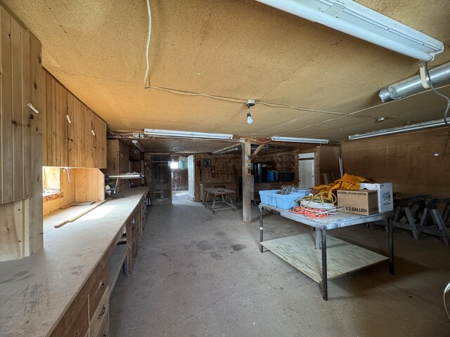 143 Main St, Sangerville, ME 04479 - misc room with a workshop area, unfinished concrete floors, wood walls, and a garage