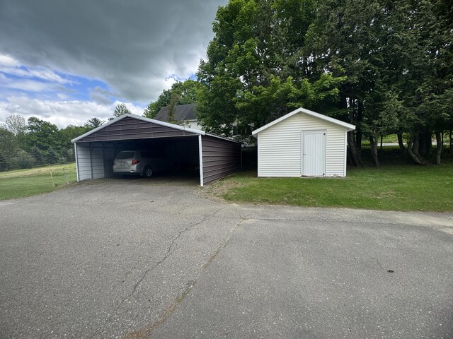 143 Main St, Sangerville, ME 04479 - detached garage featuring a storage unit and a detached carport