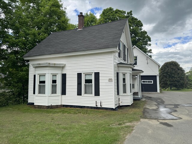143 Main St, Sangerville, ME 04479 - view of front of home featuring driveway, a chimney, a front lawn, and a shingled roof