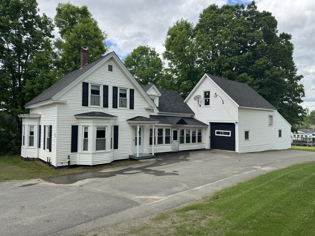 143 Main St, Sangerville, ME 04479 - view of front facade featuring asphalt driveway, a chimney, roof with shingles, and an outdoor structure