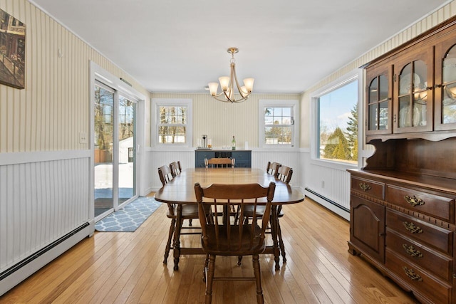 dining room featuring light wood-type flooring, a baseboard radiator, and a chandelier