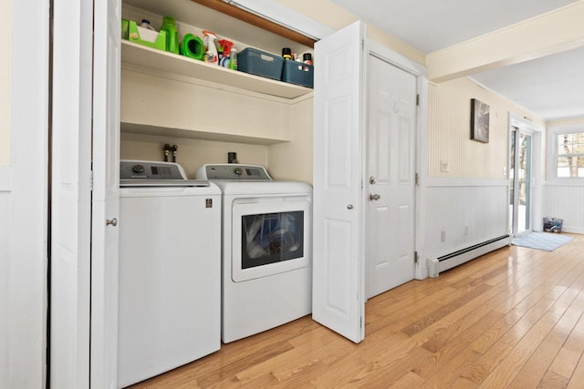 laundry room featuring washing machine and clothes dryer, laundry area, a baseboard heating unit, and light wood-style floors