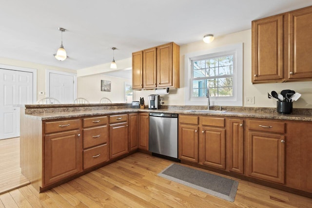 kitchen featuring a sink, brown cabinets, and dishwasher