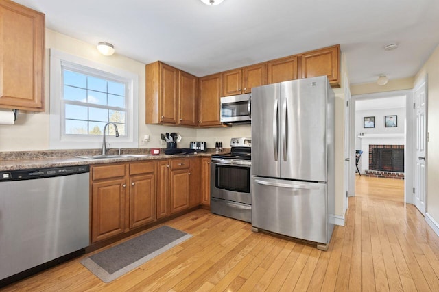 kitchen featuring a sink, light wood-style floors, and stainless steel appliances