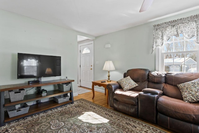 living area with baseboards and wood finished floors