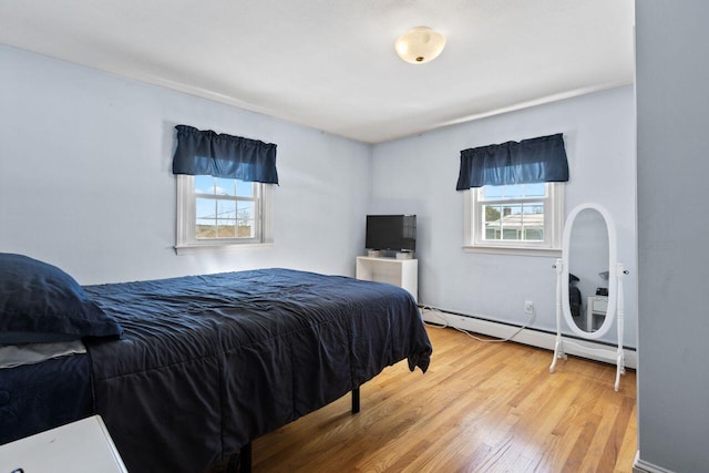 bedroom featuring baseboard heating and wood finished floors