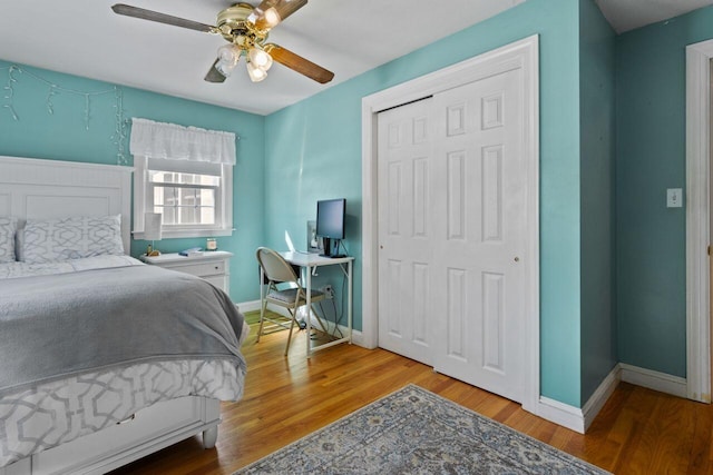 bedroom with wood finished floors, baseboards, and a closet