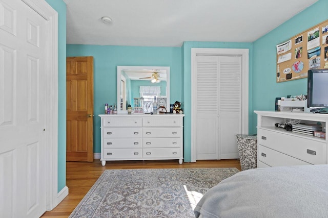 bedroom with wood finished floors, a closet, and baseboards