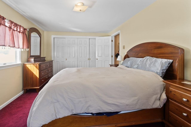 bedroom featuring a closet, baseboards, and dark colored carpet