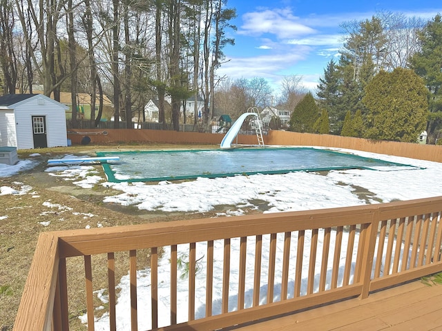 view of pool featuring a fenced in pool, an outdoor structure, a water slide, and a fenced backyard