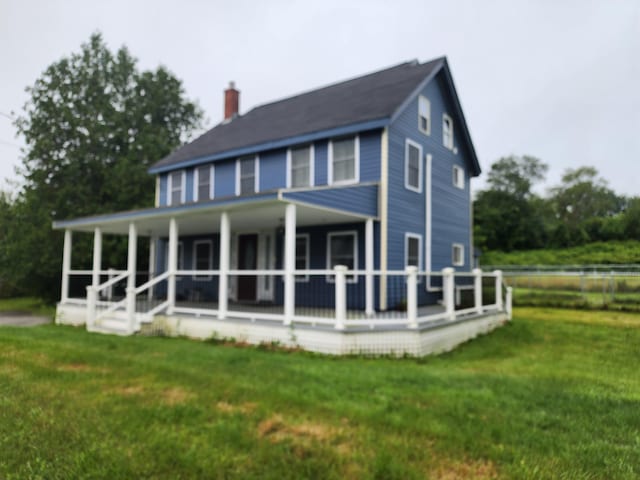 view of front facade with a front yard and a chimney