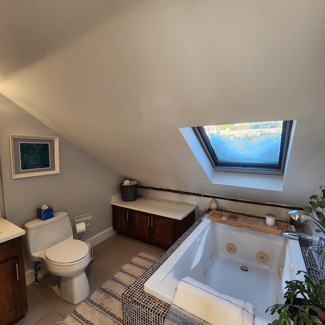 bathroom with vaulted ceiling with skylight, toilet, tile patterned floors, a whirlpool tub, and vanity