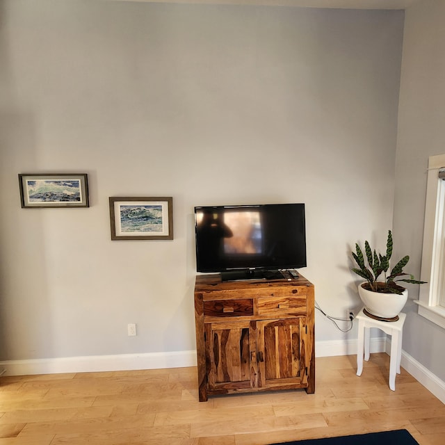 living area with light wood-type flooring and baseboards