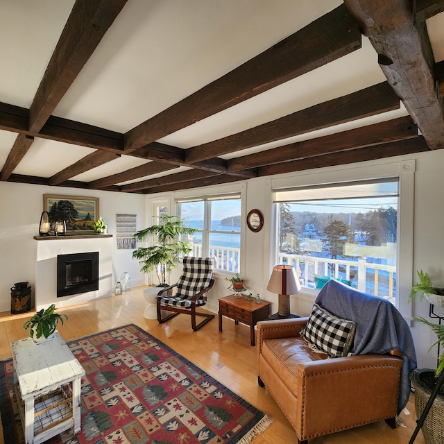 living room featuring beam ceiling, a fireplace, and hardwood / wood-style floors