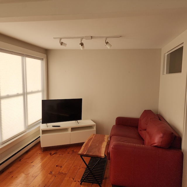 living room featuring light wood-type flooring and a baseboard heating unit