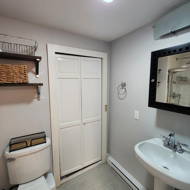 full bathroom with baseboards, toilet, an enclosed shower, baseboard heating, and a sink