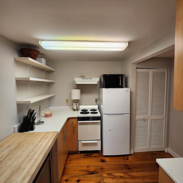 kitchen with under cabinet range hood, white appliances, light countertops, open shelves, and dark wood finished floors