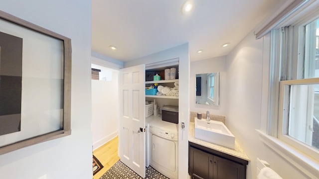 bathroom featuring separate washer and dryer, wood finished floors, vanity, and recessed lighting