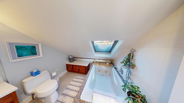 full bathroom with vaulted ceiling with skylight, tile patterned flooring, toilet, vanity, and a tub with jets