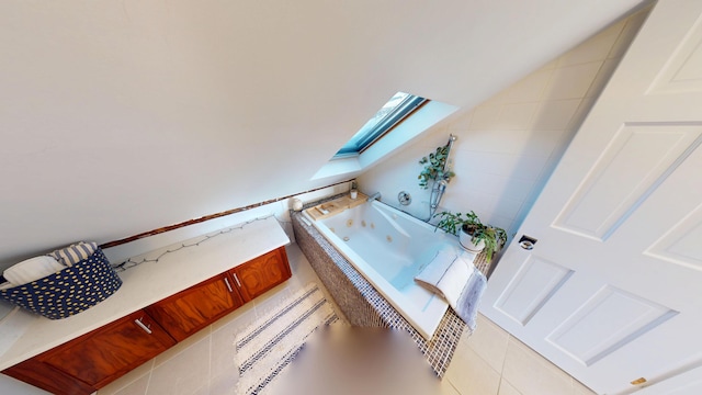 bathroom with a skylight and a tub with jets