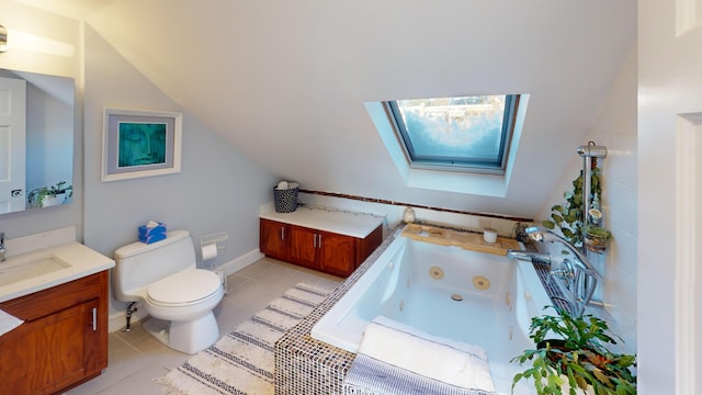 full bath featuring toilet, vanity, vaulted ceiling with skylight, a whirlpool tub, and tile patterned floors