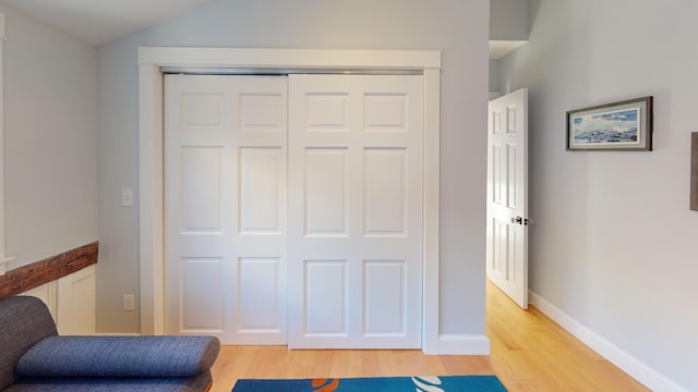 living area with lofted ceiling, light wood-style floors, and baseboards