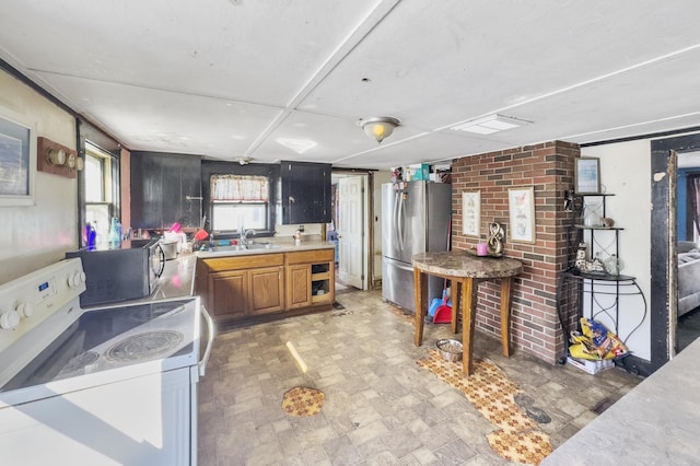 kitchen featuring appliances with stainless steel finishes, brown cabinets, light countertops, and a sink