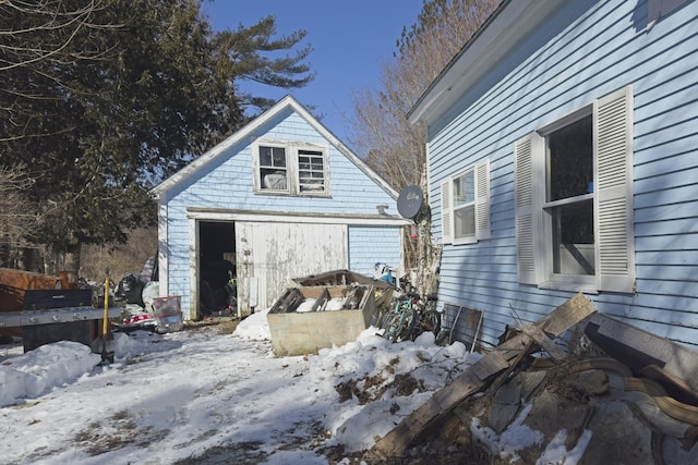 view of snowy exterior featuring an outbuilding