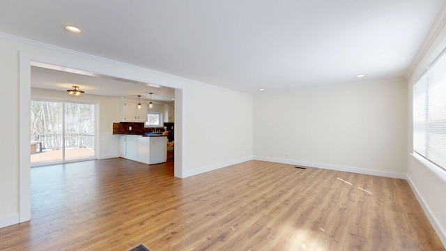 unfurnished living room with visible vents, baseboards, ornamental molding, recessed lighting, and light wood-style floors