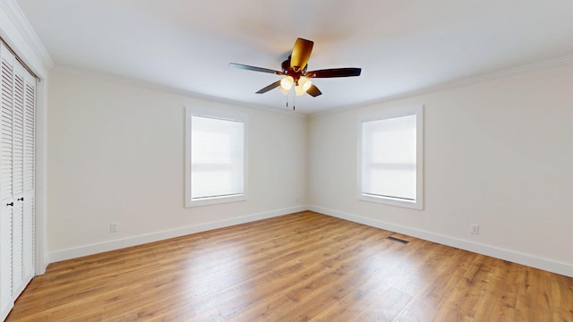 unfurnished bedroom with visible vents, light wood-type flooring, baseboards, and ornamental molding