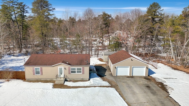 view of front of house with a detached garage, roof with shingles, and fence