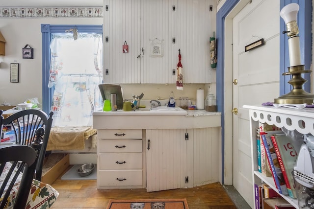 kitchen with light countertops, a sink, and hardwood / wood-style floors