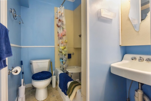 bathroom featuring shower / bathtub combination with curtain and toilet