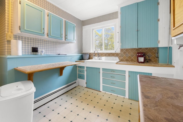 70 Savage St, Bangor, ME 04401 - kitchen with a baseboard radiator, light floors, blue cabinets, decorative backsplash, and light countertops