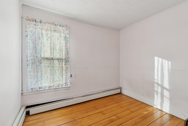 unfurnished room with a baseboard radiator and hardwood / wood-style floors