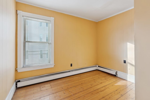 unfurnished room with baseboard heating and wood-type flooring