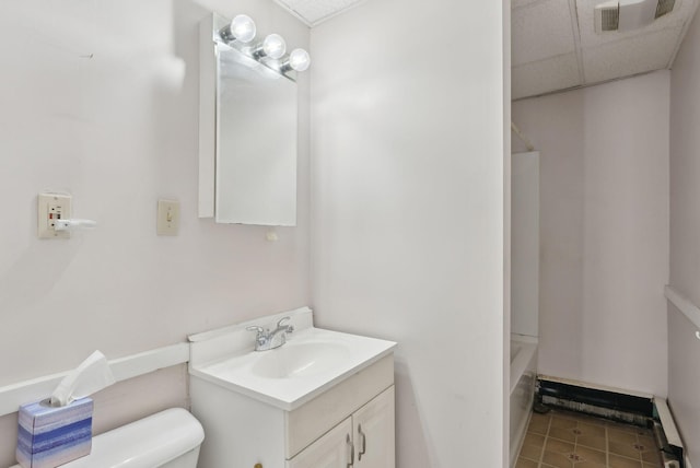 bathroom with tile patterned flooring, visible vents, toilet, vanity, and a paneled ceiling