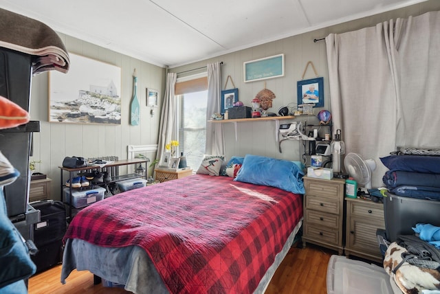 bedroom featuring wood finished floors and crown molding