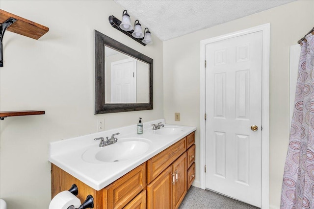 bathroom featuring double vanity, a textured ceiling, and a sink