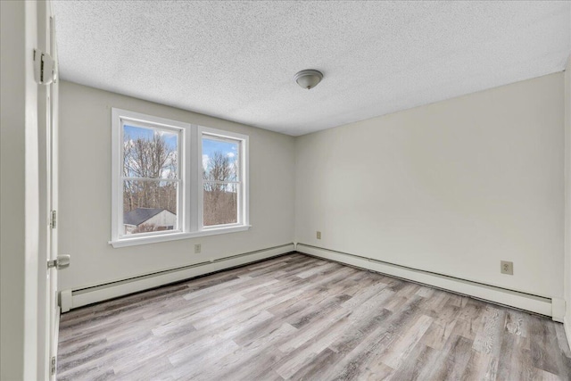 unfurnished room featuring a textured ceiling, baseboard heating, and wood finished floors